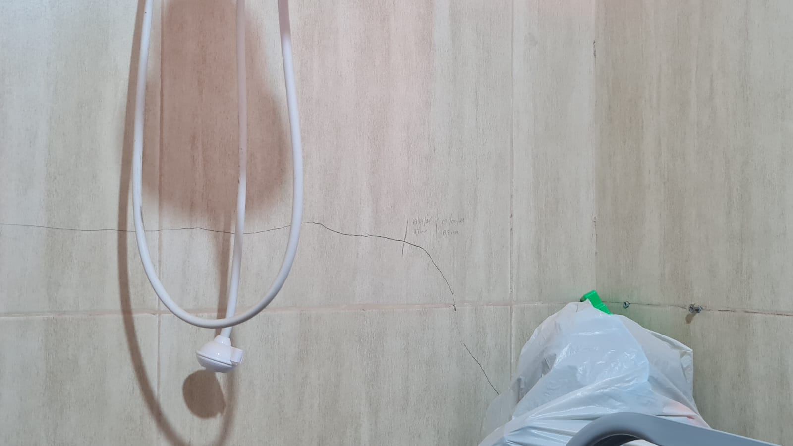 Fissura horizontal em revestimento cerâmico de parede interna identificada durante vistoria técnica.