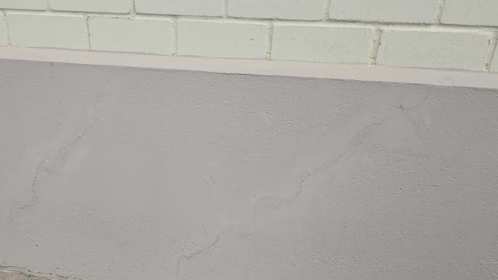 Fissuras em revestimento de fachada externa identificadas durante vistoria de constatação técnica.