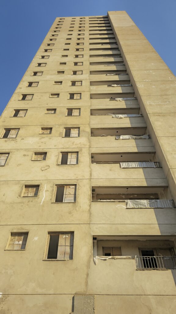Fachada vertical entre torres de edifício em construção durante inspeção técnica.