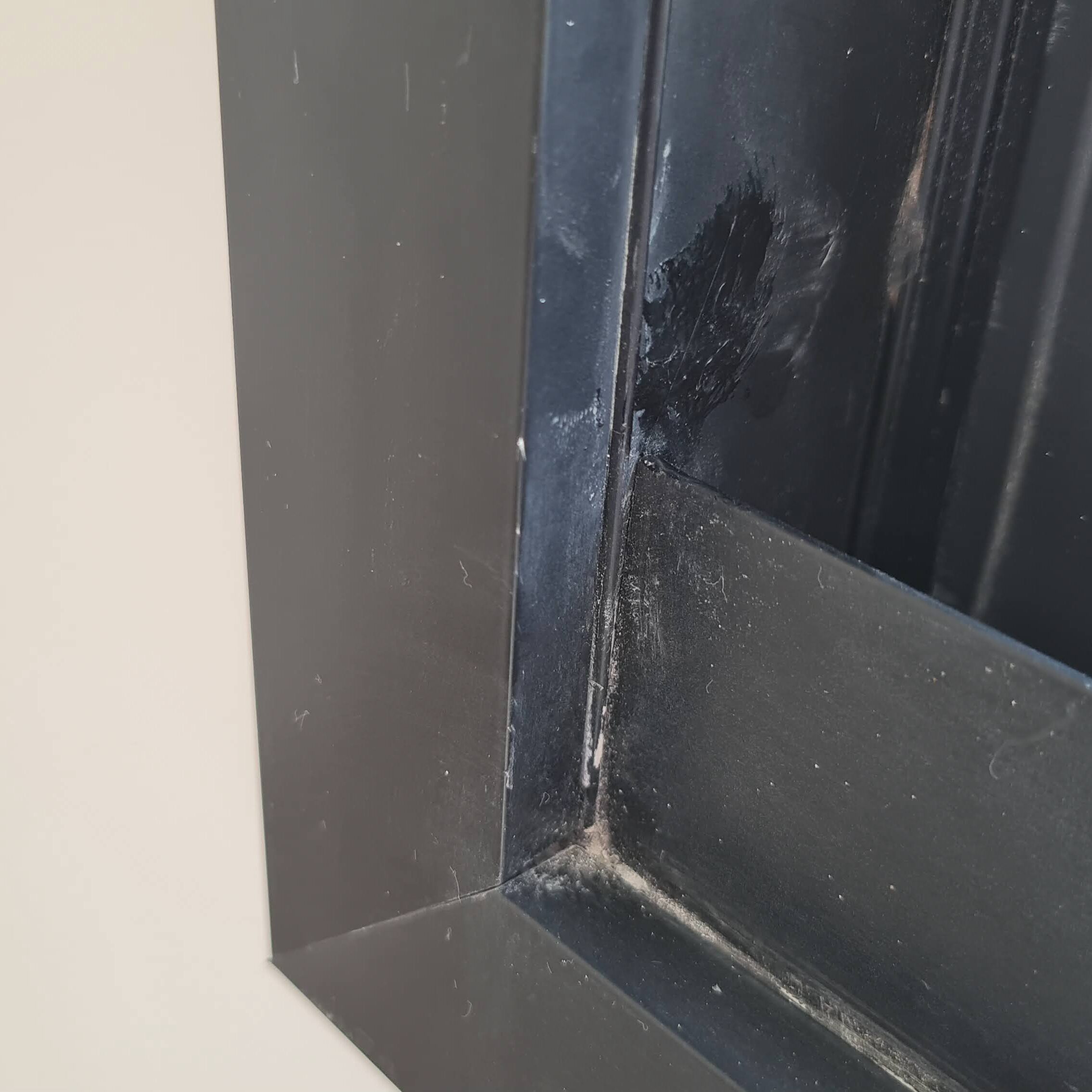 Riscos em esquadria de alumínio preta identificados durante vistoria técnica.