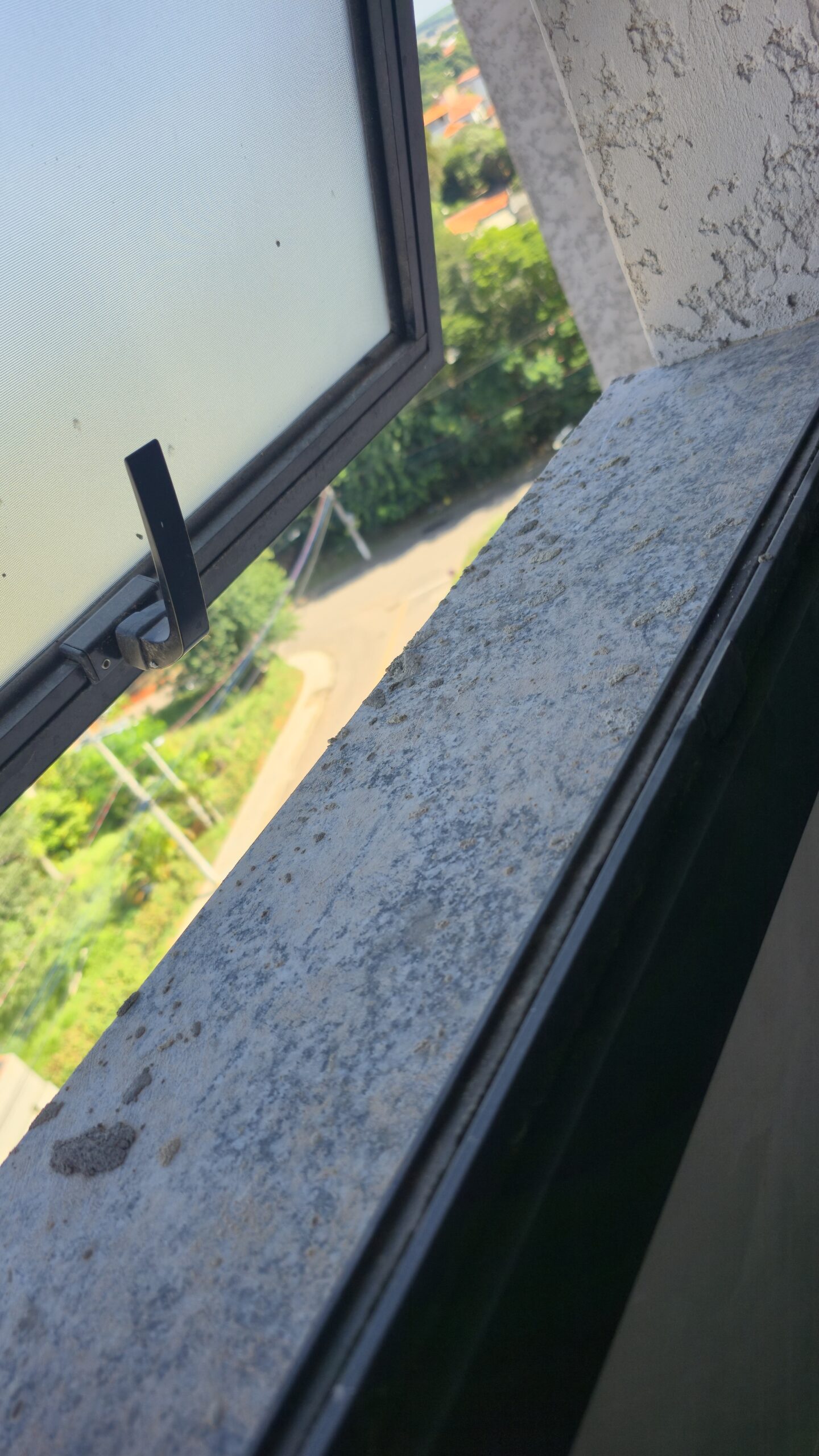 Sujeira e manchas em peitoril de janela com sinais de desgaste e danos superficiais.