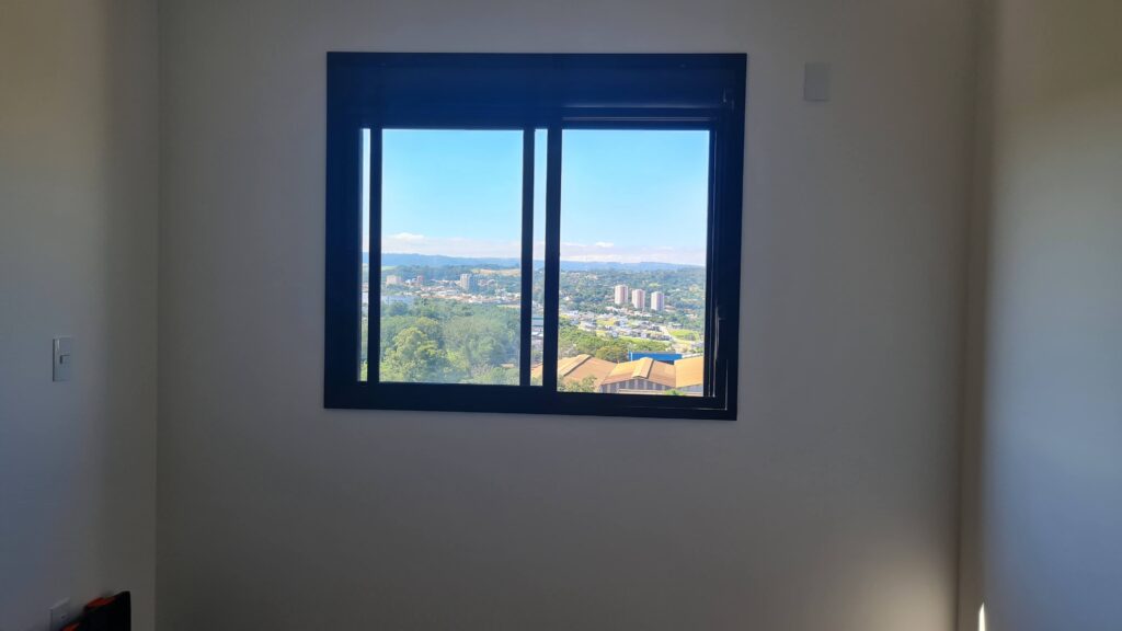 Quarto de imóvel novo com duas janelas e pontos elétricos avaliados durante vistoria técnica.