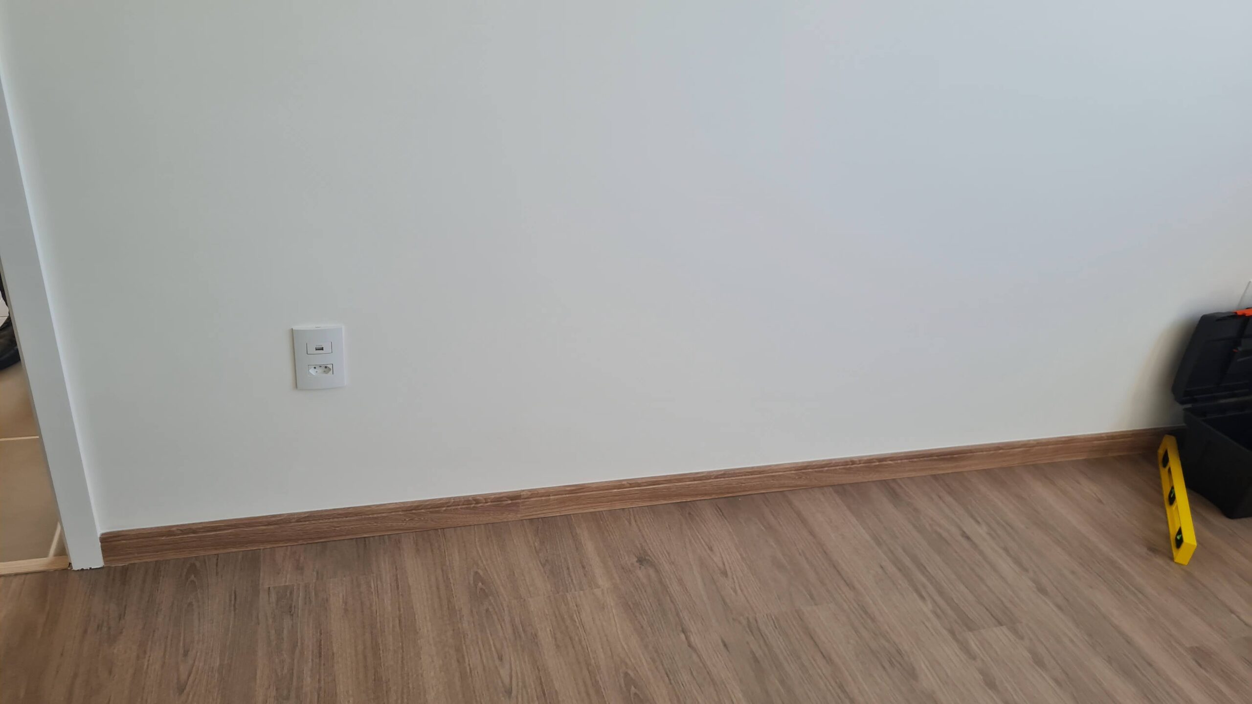 Rodapé e piso amadeirado de imóvel novo avaliados durante vistoria técnica de acabamento.