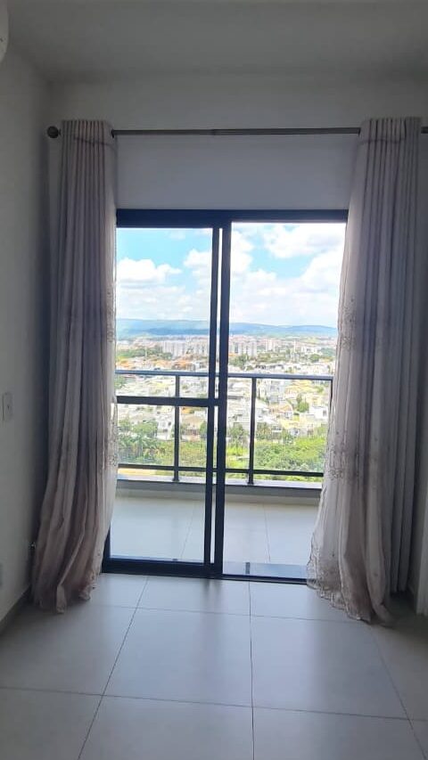 Sala de imóvel novo com porta de vidro para sacada, cortinas, piso cerâmico e ar-condicionado avaliados durante vistoria técnica.